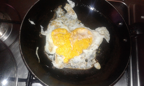 Image heart shaped egg on the pan